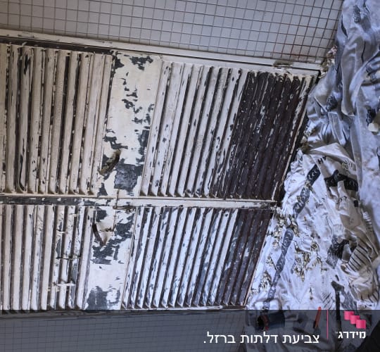 דלת עץ מתקלפת עם כלי עבודה לצביעה